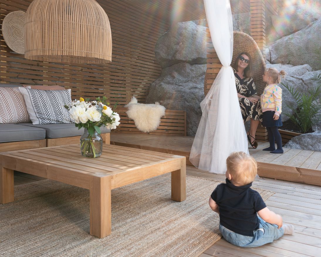 Mor og barn som koser seg på termofuruterrasse fra Moelven