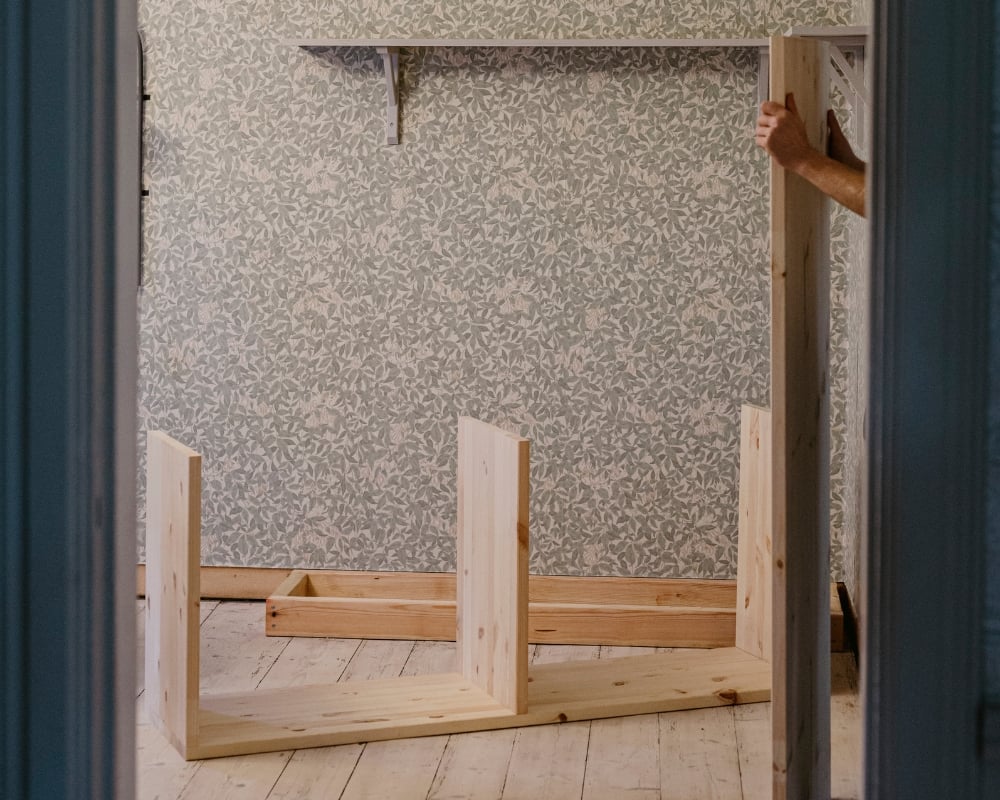 En hylla av trä monteras ihop