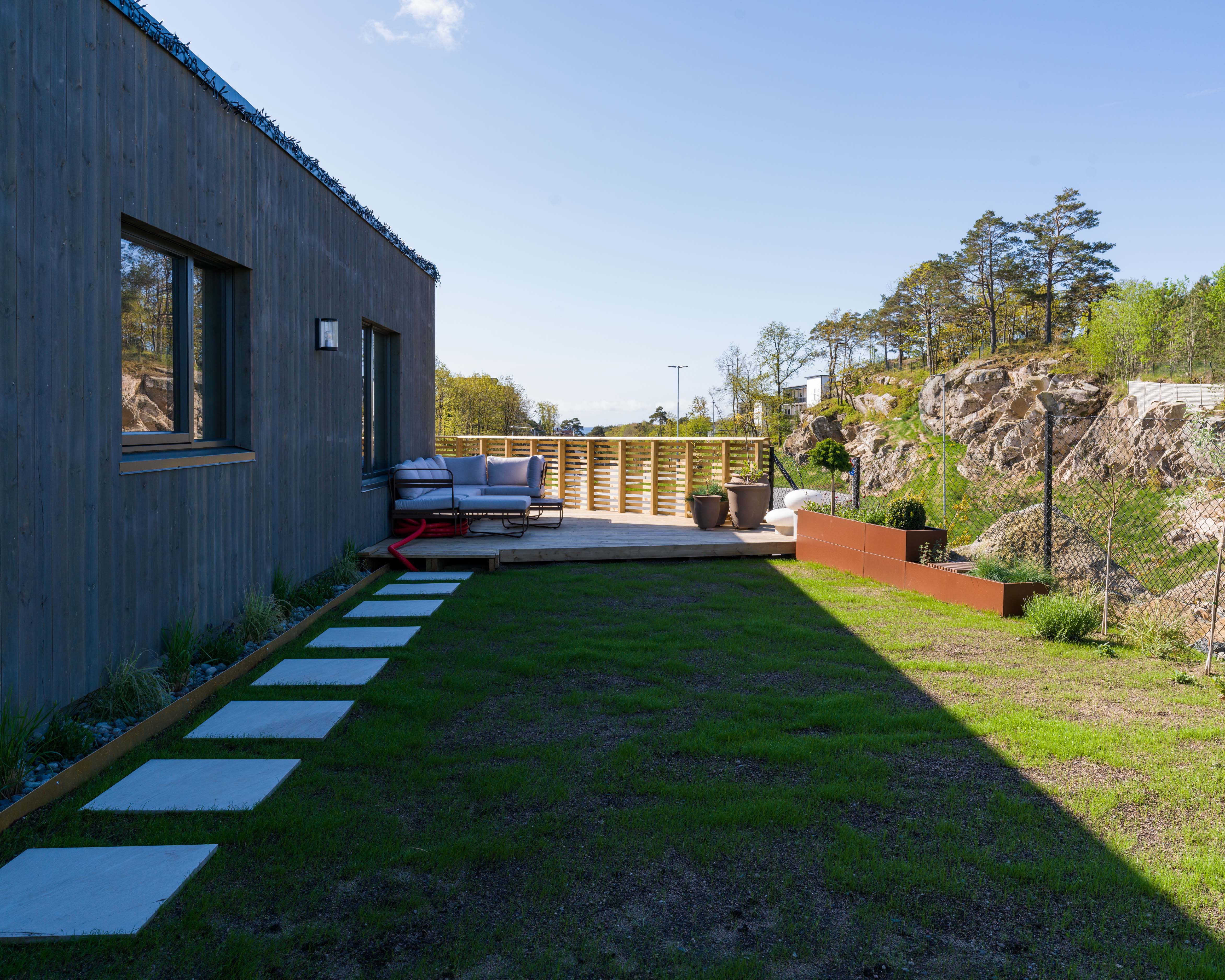 Moderne hus med nyetablert hage med tråkkheller og beplantning