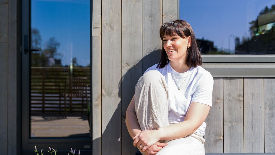 Person i hvit t-skjorte som sitter på en bank på en terrasse