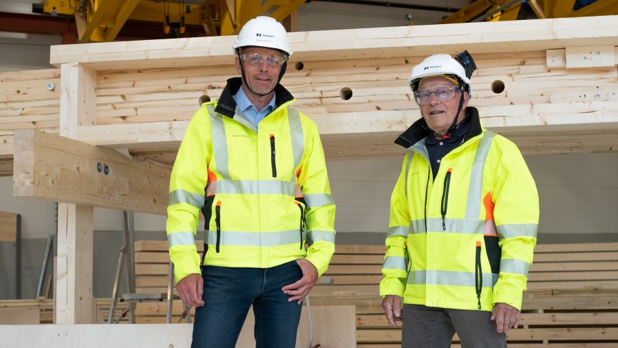 Rune Abrahamsen og Åge Holmestad i vernebekledning, synlighetsbekledning foran limtre. Foto