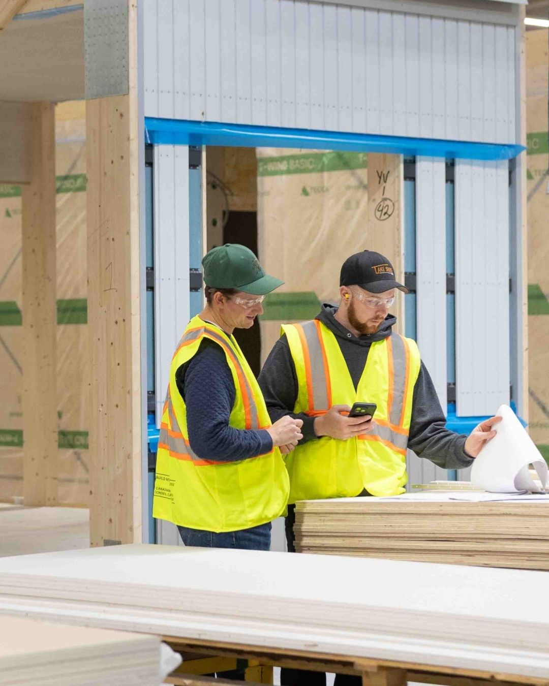 Två personer tittar på papper i fabrik