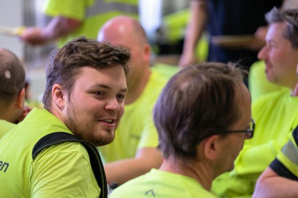 glada medarbetare i gula signalkläder