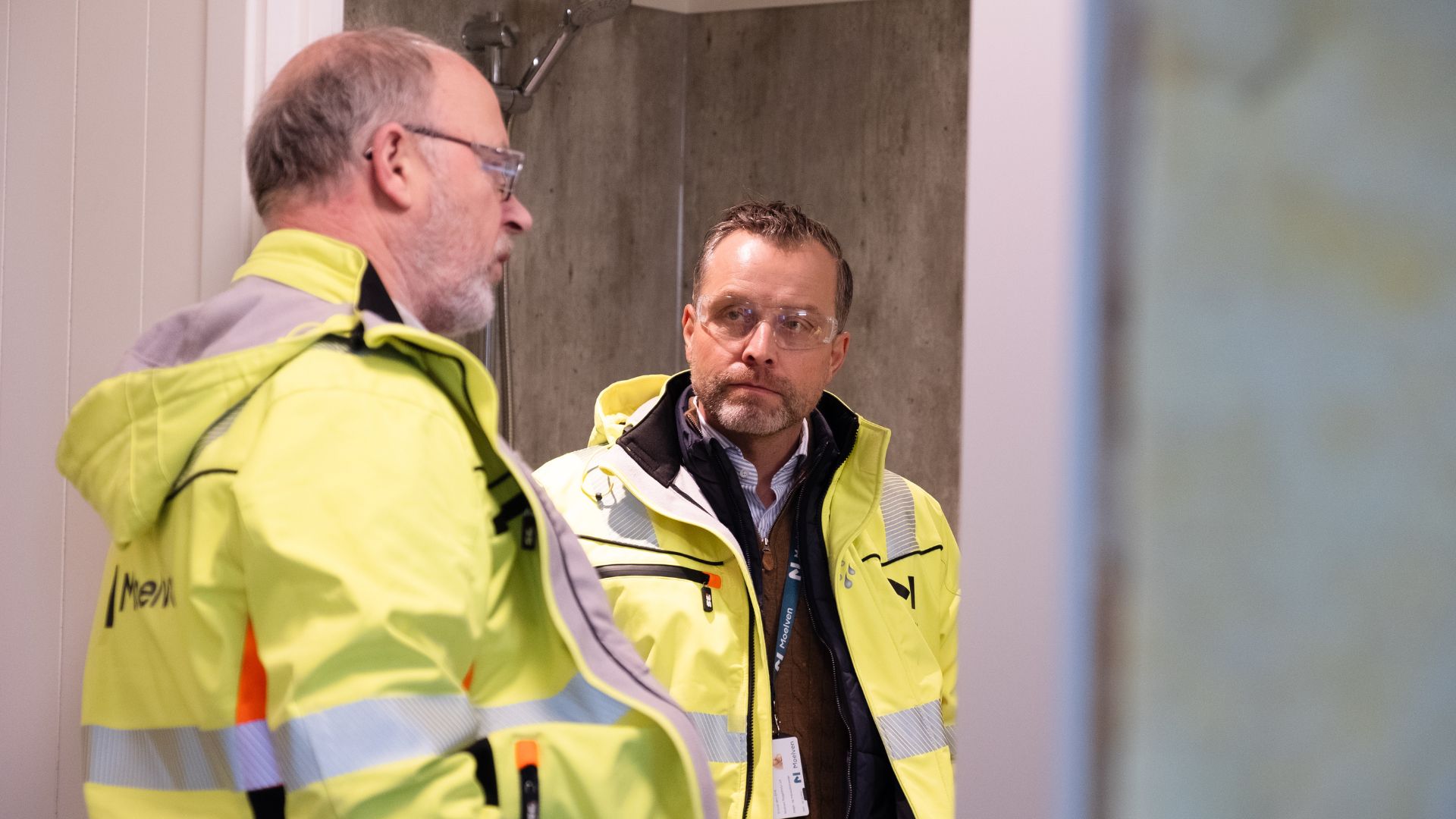 To menn i refleksjakker som er inne i en buggmodul.