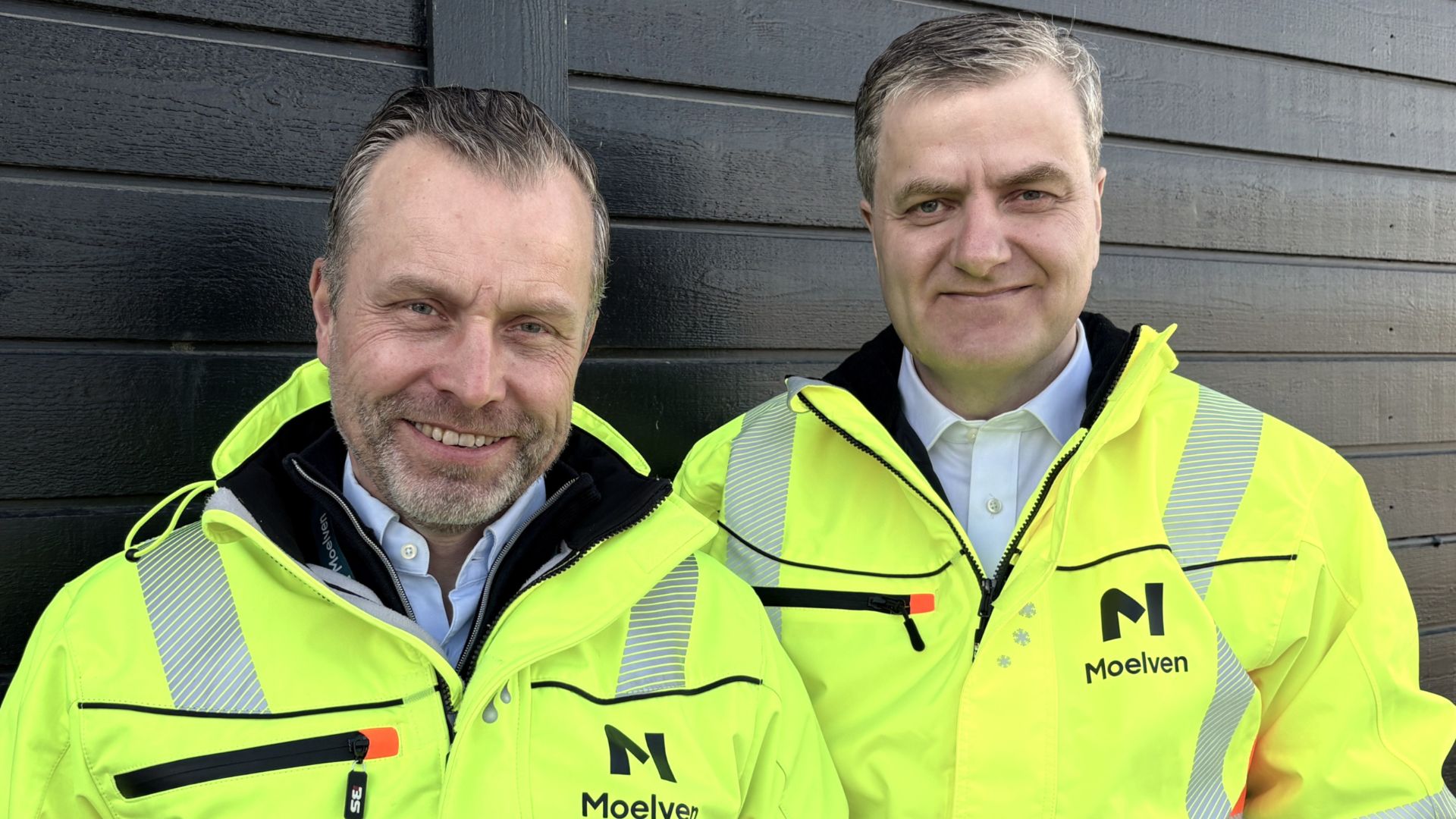 To smilende personer i Moelven synlighetsklær.