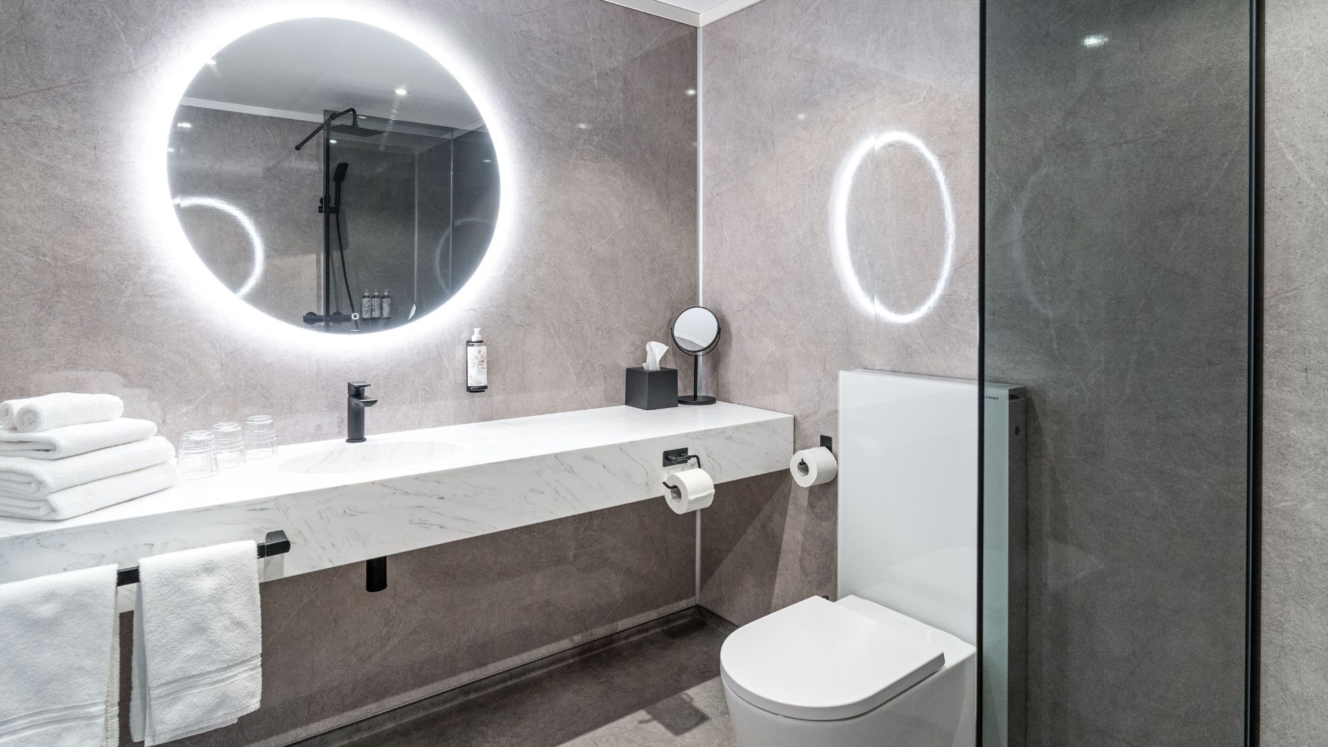 Moderne bad i tidsriktig design og delikate farge produsert innendørs i fabrikken hos Moelven Byggmodul. 