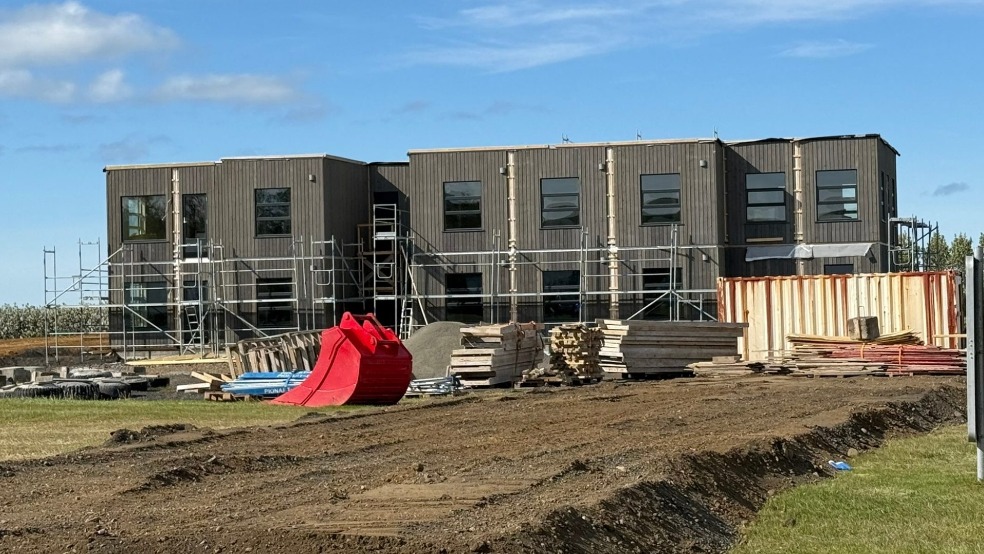 Toetasjes modulbygg under oppføring. Med stillas og byggevarer.