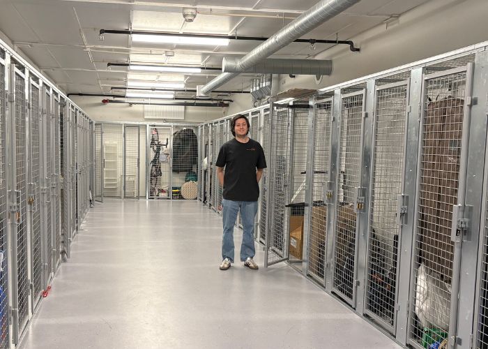 Person som står i en gitterbygd bodkjeller.