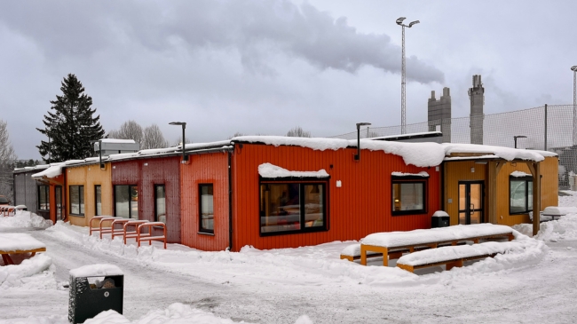 Modulbygg med moduler i forskjellige farger. Vinterlandskap med snø.