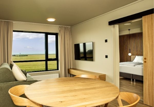 Hotellrom med store vinduer ut mot et vidstarkt landskap.