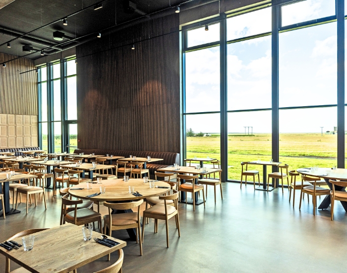 Spisesal på et hotell med store vinduer ut med åpent landskap.