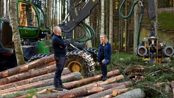 Avverkad skog tillsammans med två personer i skogen