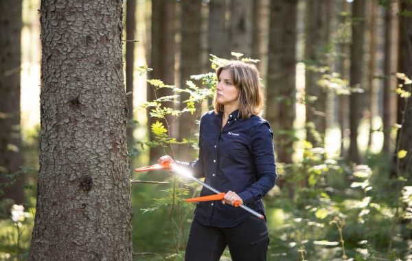 Person i skogen med timmer