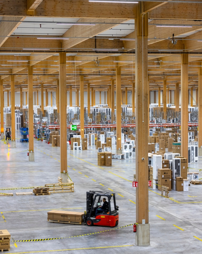 Truck som körer inuti lager med limträbalkar