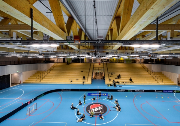 Inuti Österåker multiarena, människor som sitter i en stor ring på det blåa golvet