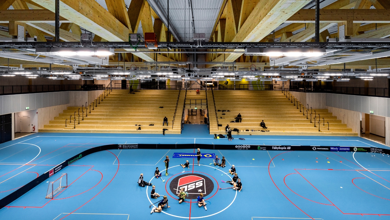 Inuti Österåker multiarena, människor som sitter i en stor ring på det blåa golvet