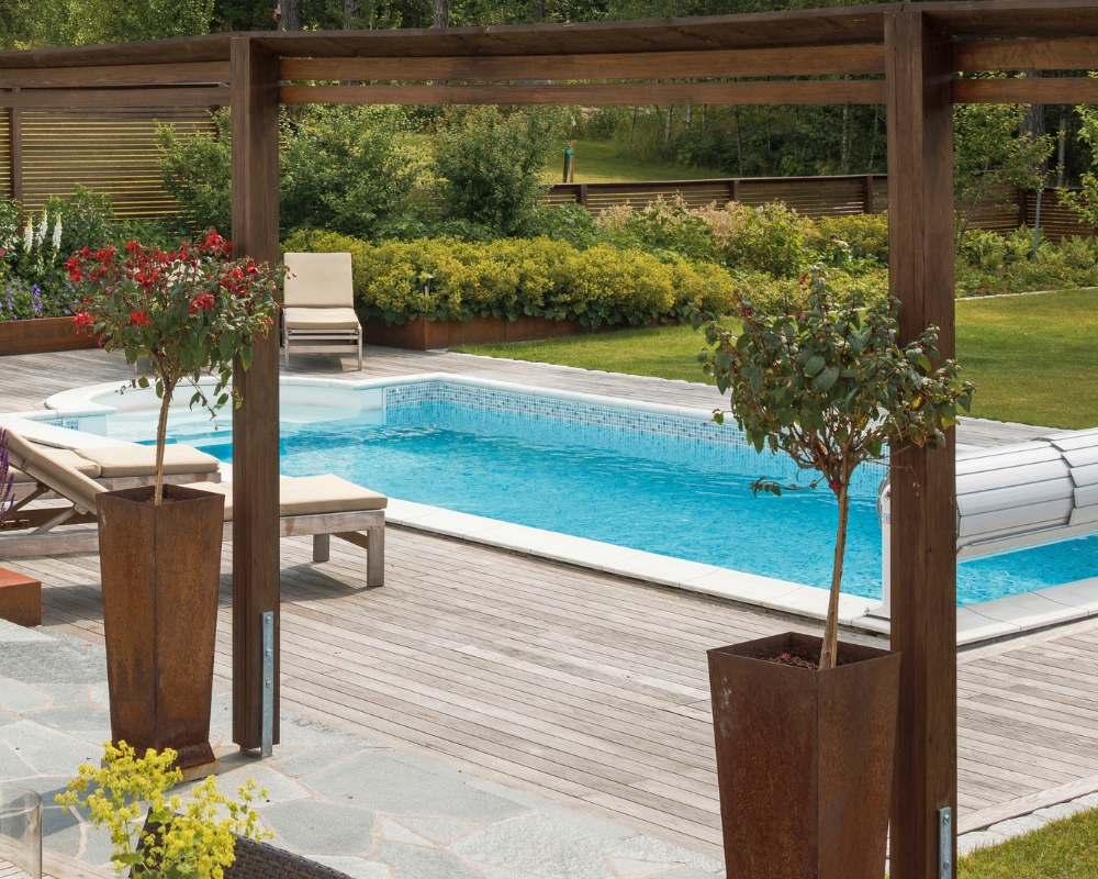 En trall i ThermoAsk och en trädgård med växter, allt ifrån blommor till buskar, samt en pool och solsängar