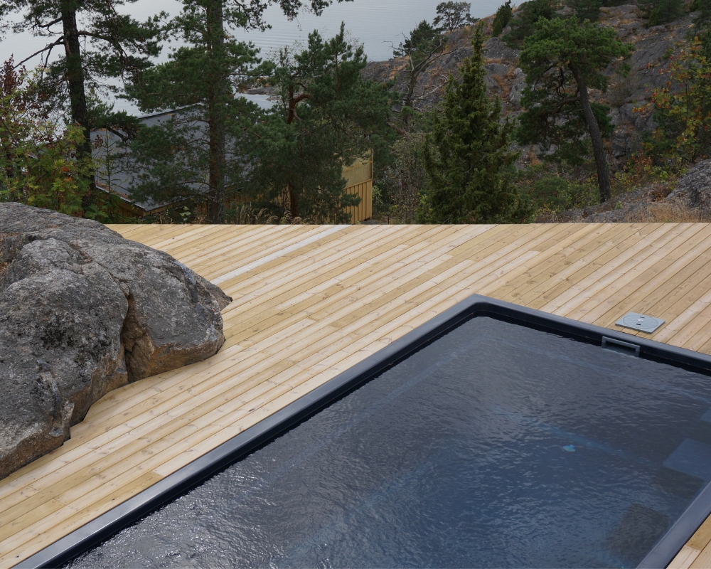 En trall med pool, utsikt utöver en skog