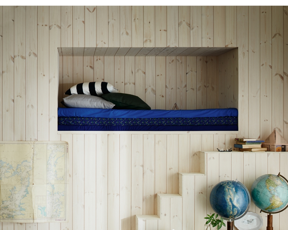 En sovhörna med träpanel, samt jordglober