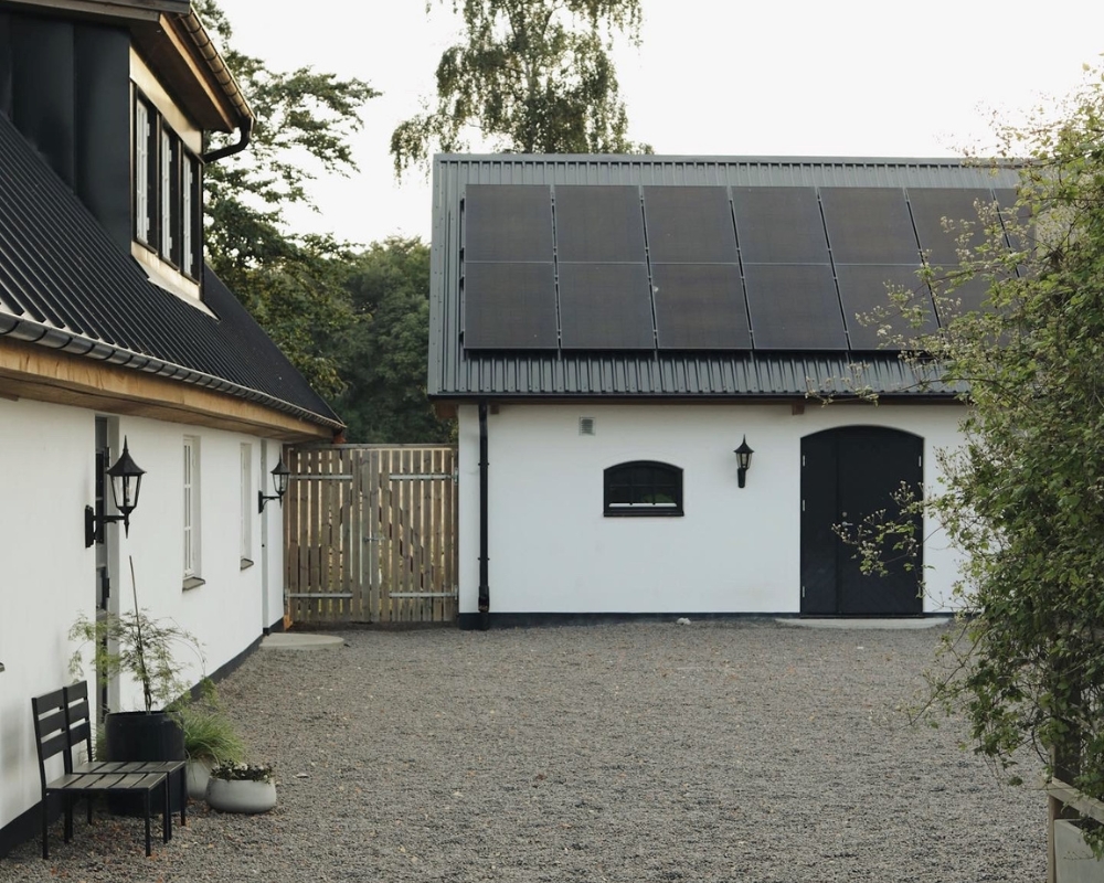 Två vita hus och en innergård med grus