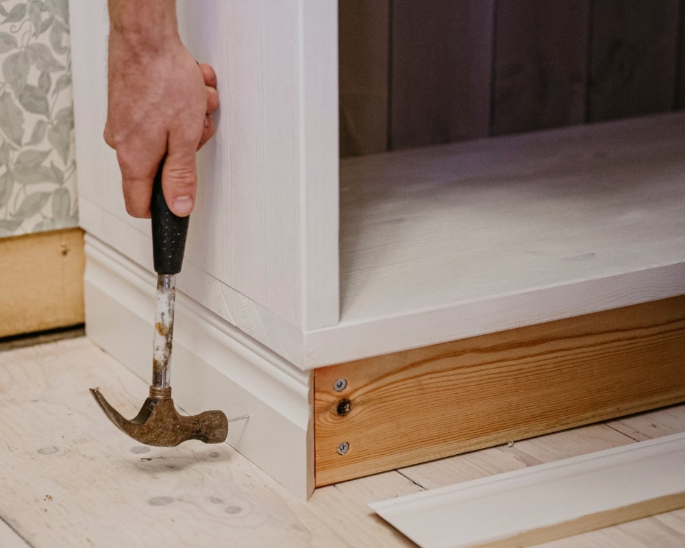 En list spikas fast på nederdelen av en hylla