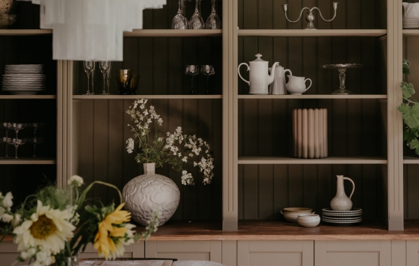 Sovrum med säng, sängbord och en skiljevägg i svart och plexiglas