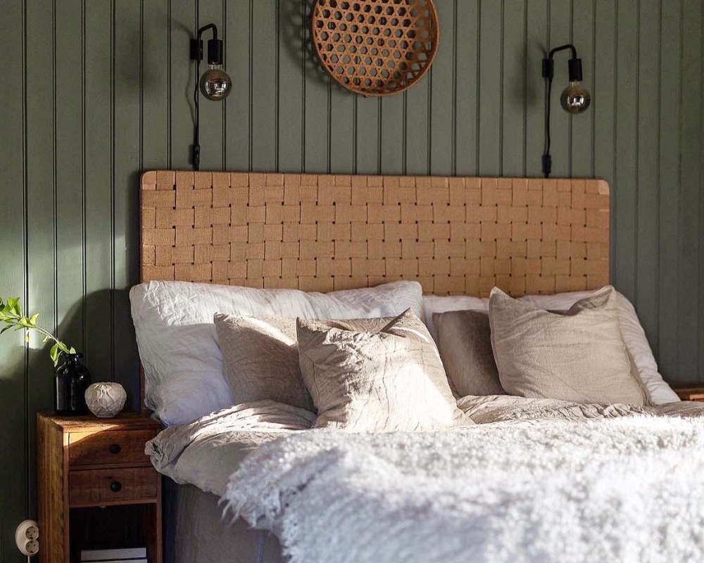 Ett sovrum med grön pärlspont träpanel, en säng och dekorationer