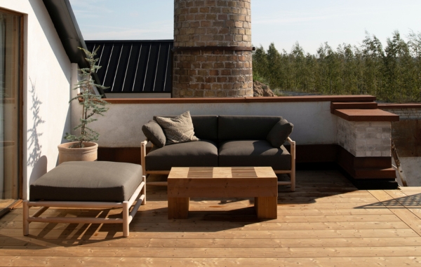 En altan med stenmur och trall, samt möbler i trä