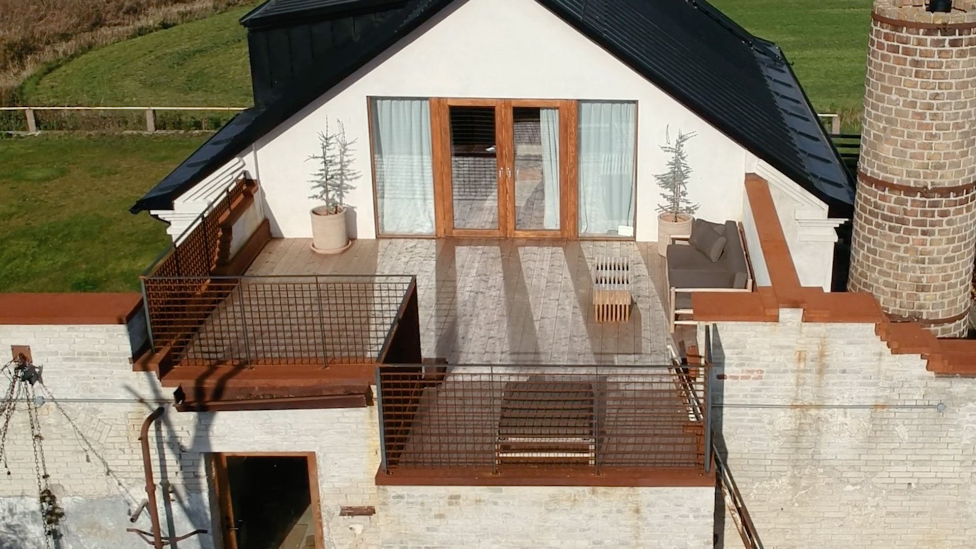 Översiktsbild av den färdiga takterrassen på Stärkelsefabriken, byggd i TermoGran, med dubbelglasdörrar, loungemöbler och utsikt över det omgivande landskapet.