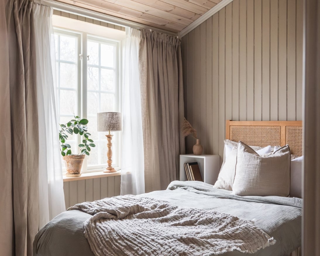 Sovrum med säng, dekorationer och en beige träpanel