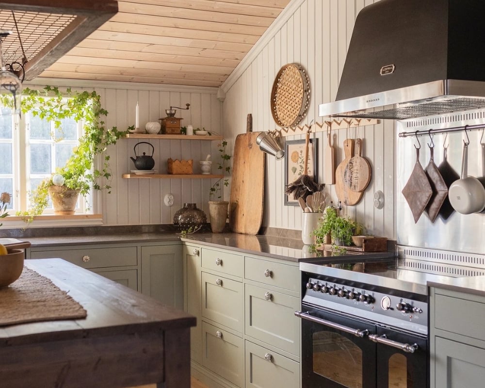 Ett kök med trä från golv till tak. En köksbänk och en köksö, samt inredningsdetaljer