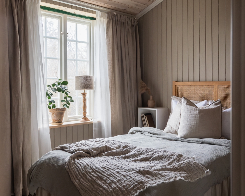 sovrum med beige pärlspont träpanel, säng och inredningsdetaljer