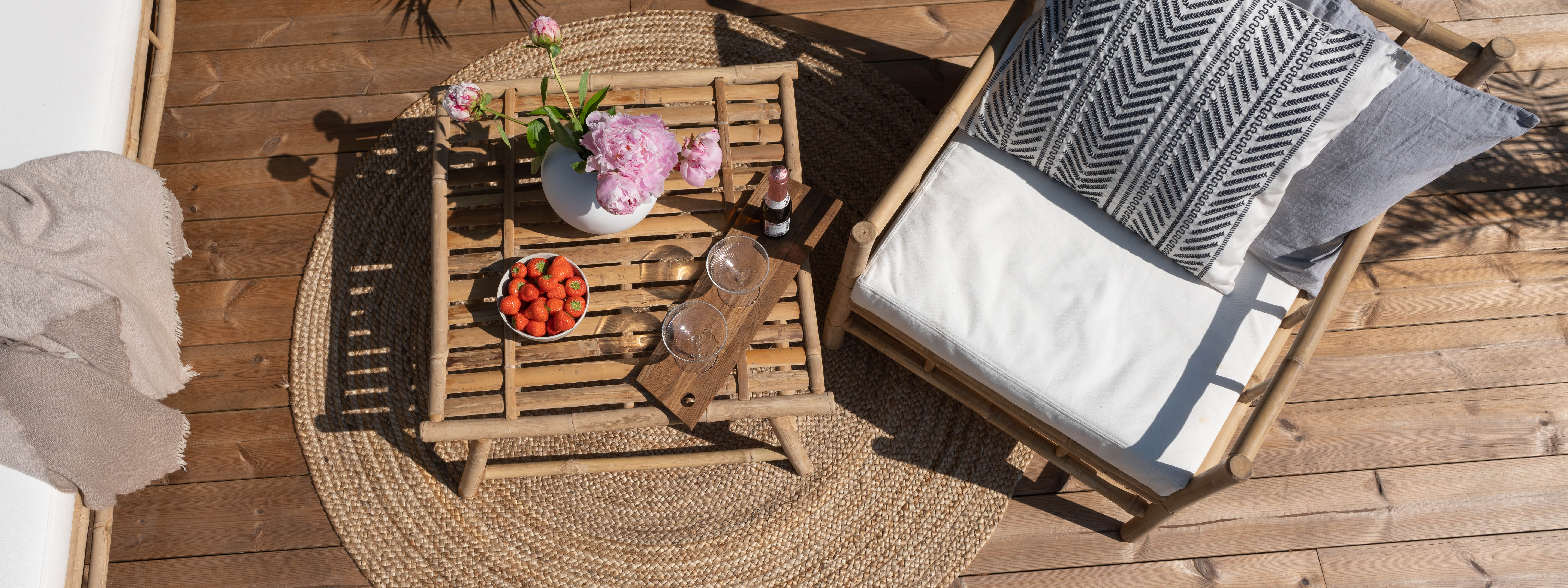 Fåtölj och dukat bord på trall av ThermoWood