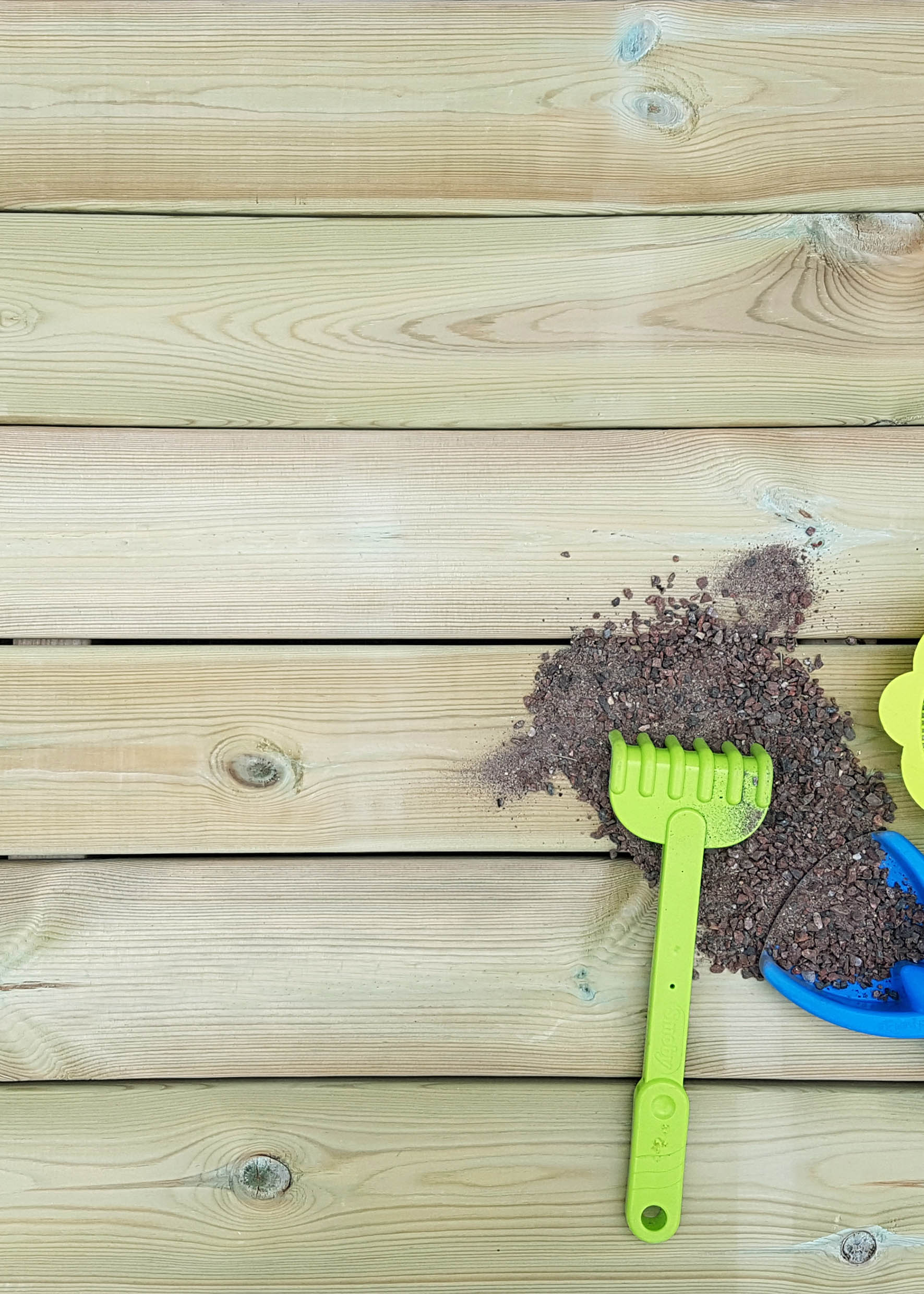 Spade och sand på tryckimpregnerad trall