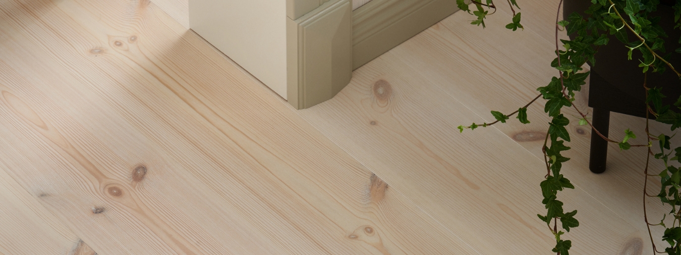 Mörkt furugolv samt en gunghäst i form av en ko.