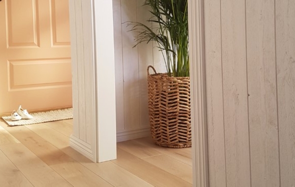 En hall med orange dörr, och vit panel