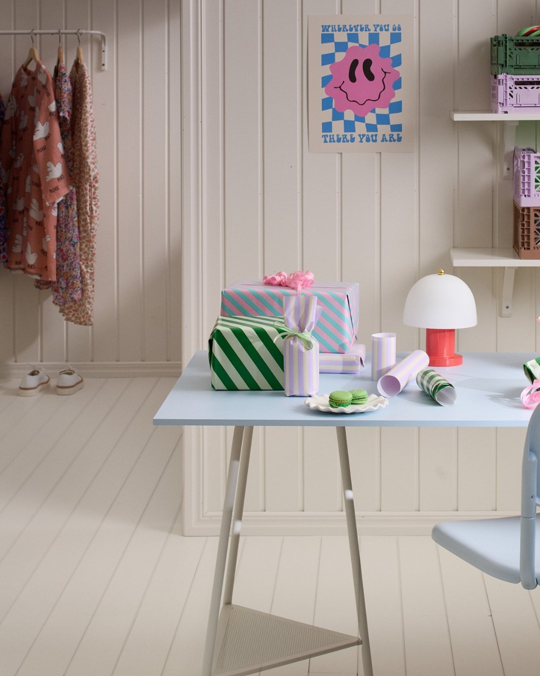 Ett arbetsrum med skrivbord och kontorsmaterial, vita paneler på väggarna och ett trägolv