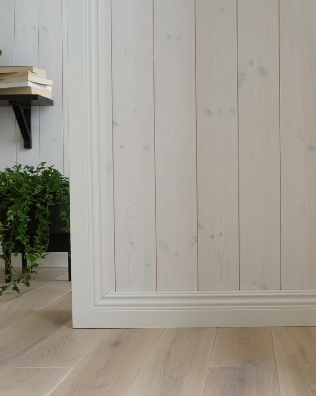 Vit lister och vit panel, samt trägolv