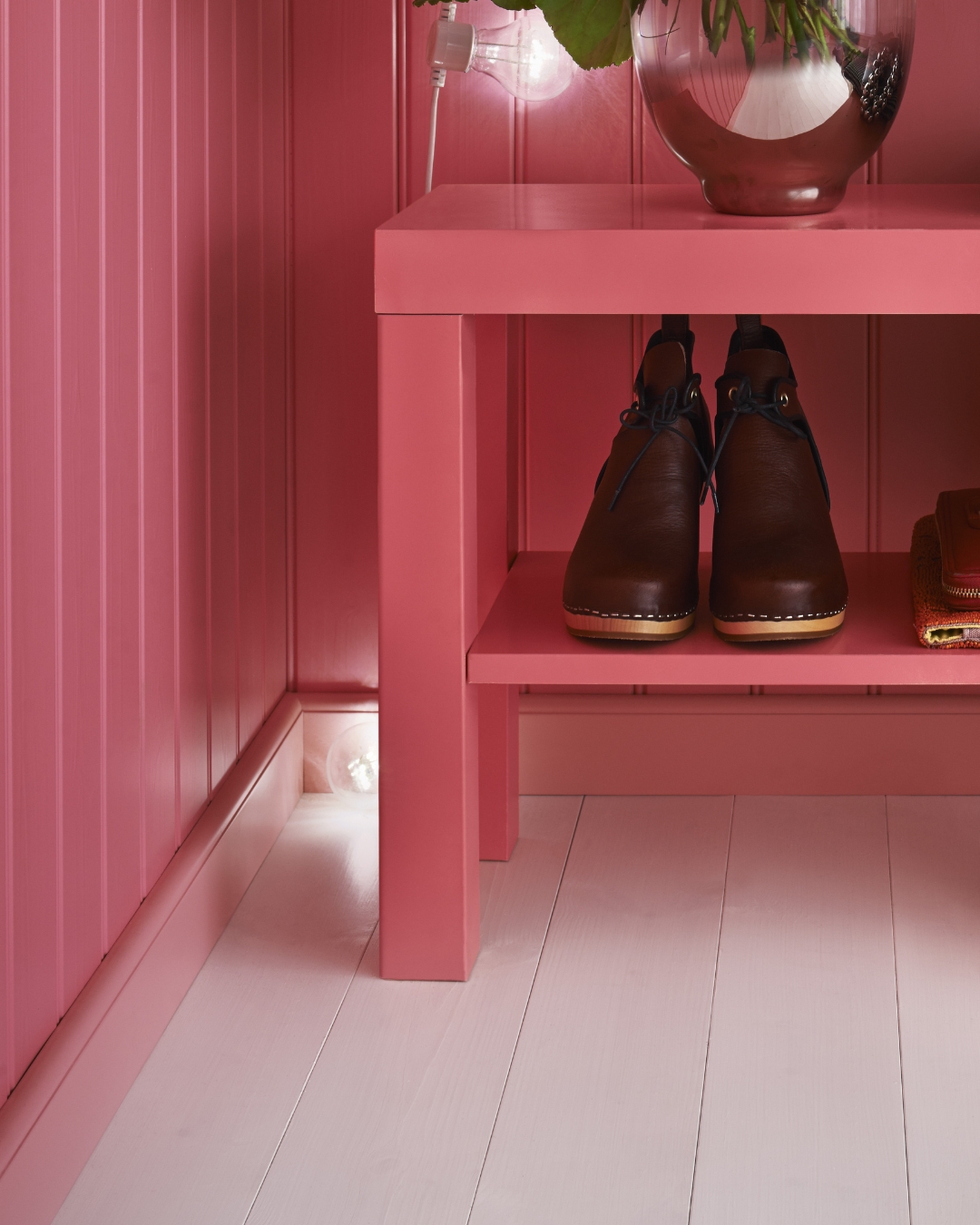 Rosa panel samt skohylla, vitt trägolv