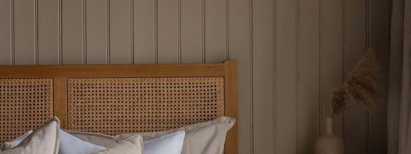 Pärlspont panel på väggen i ett sovrum med bäddad säng