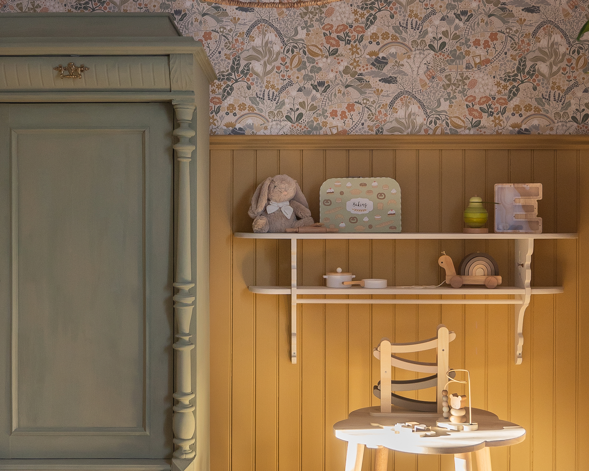 En pärlspont träpanel och en hylla med barnkläder och dekorationer