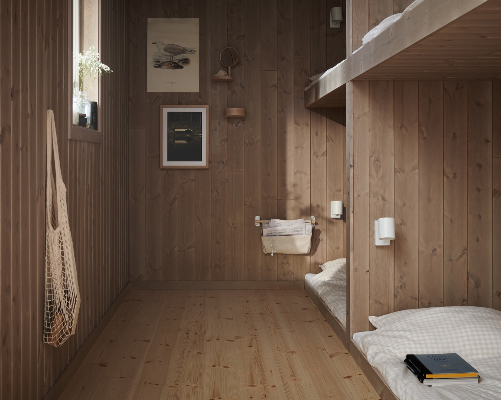 Ett sovrum med inbyggda våningssängar i trä, samt trägolv och träpanel