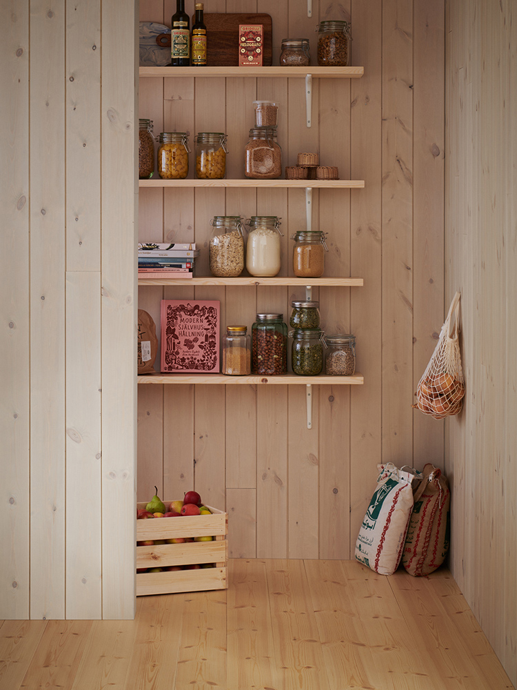 Träpanelen Stilla Morgondis sitter på väggarna. Längst bort ett öppet skafferi.