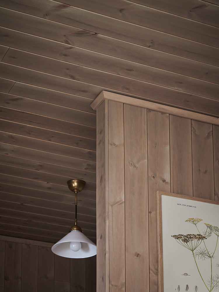 Träpanelen Stilla Sandbeige sitter på väggarna och i tak i ett sovrum