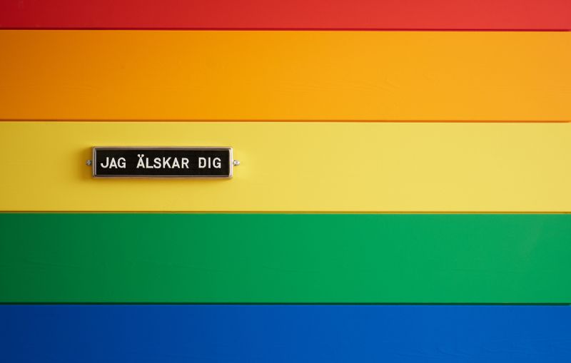 Liggande träpanel i flera starka färger och en skylt med texten jag älskar dig