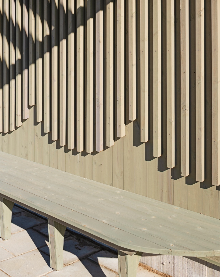 Fasadpanel med utanpåliggande ribbor i pigmenterad ThermoWood med en grön kulör.