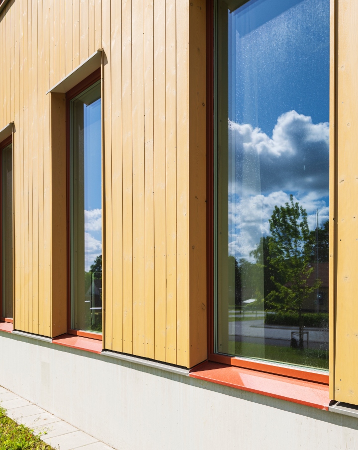 Fasad av ThermoWood BT Pigment Ockragul med fönster.