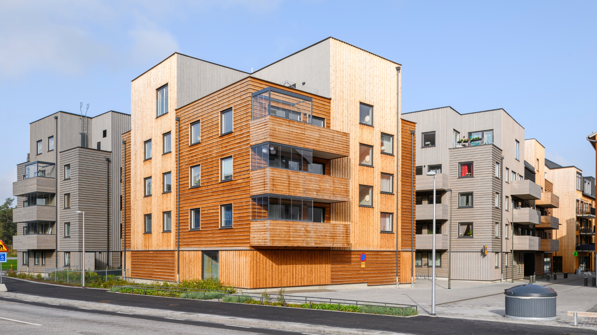 Flerbostadshus med fasad av naturlig och gråpigmenterad ThermoWood.