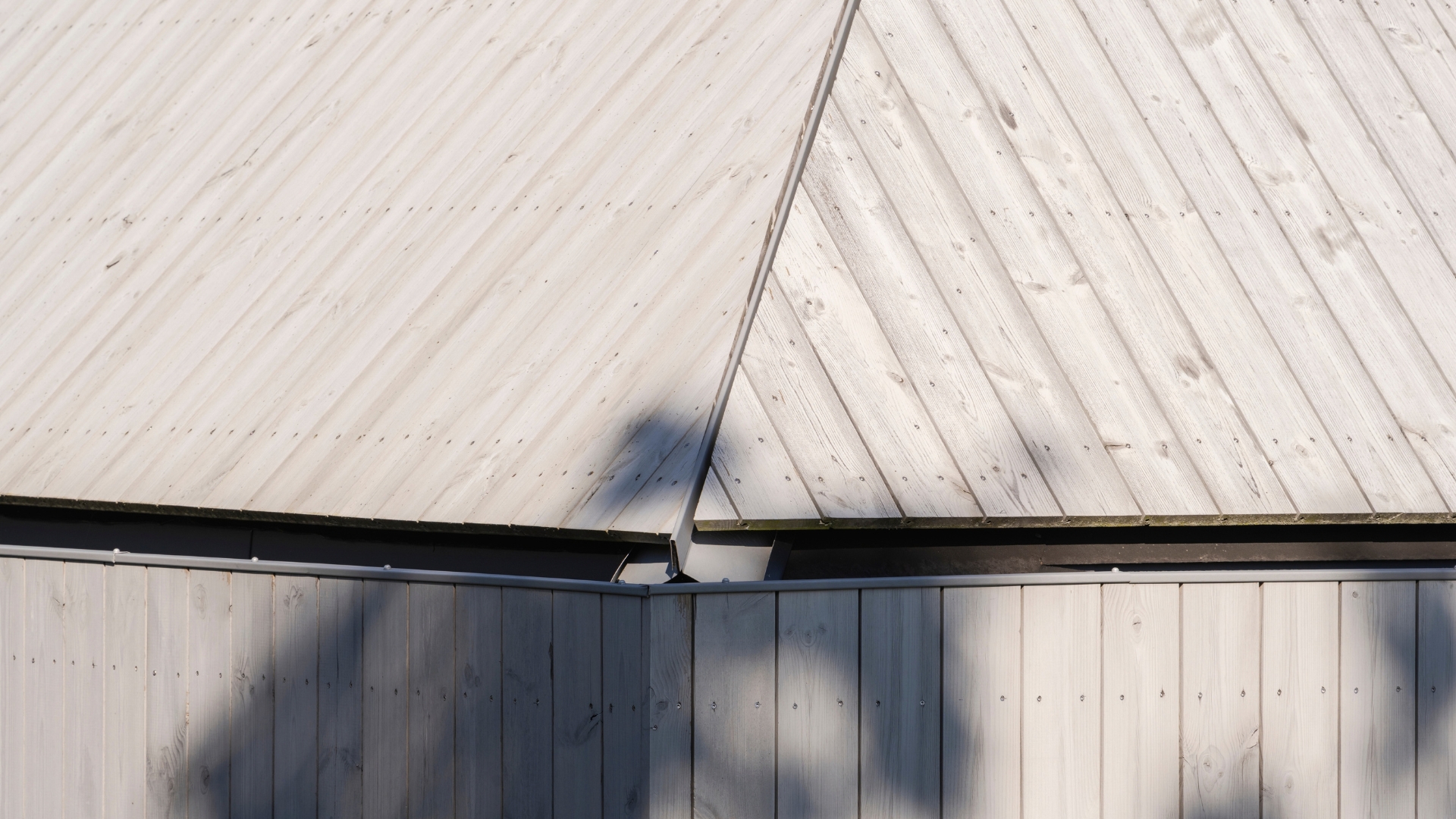 Närbild på möte mellan tak och fasadklädd med ThermoWood med Premiumolja Patinagrå