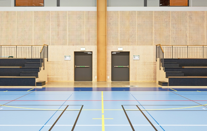 Idrottshall med perforerad plywood på väggarna.